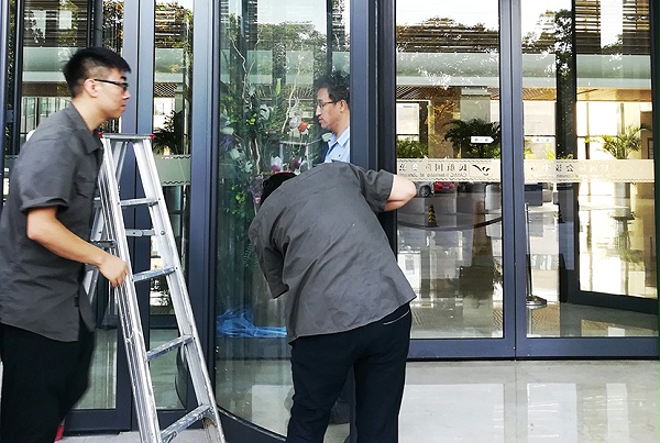 門道佰分佰北京自動(dòng)門維修師傅正在進(jìn)行自動(dòng)門保養(yǎng)